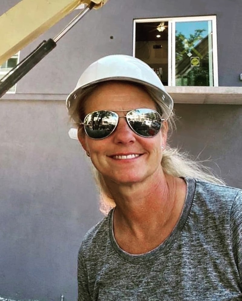 Melanie Stezzi in a white hard hat and sunglasses on a jobsite