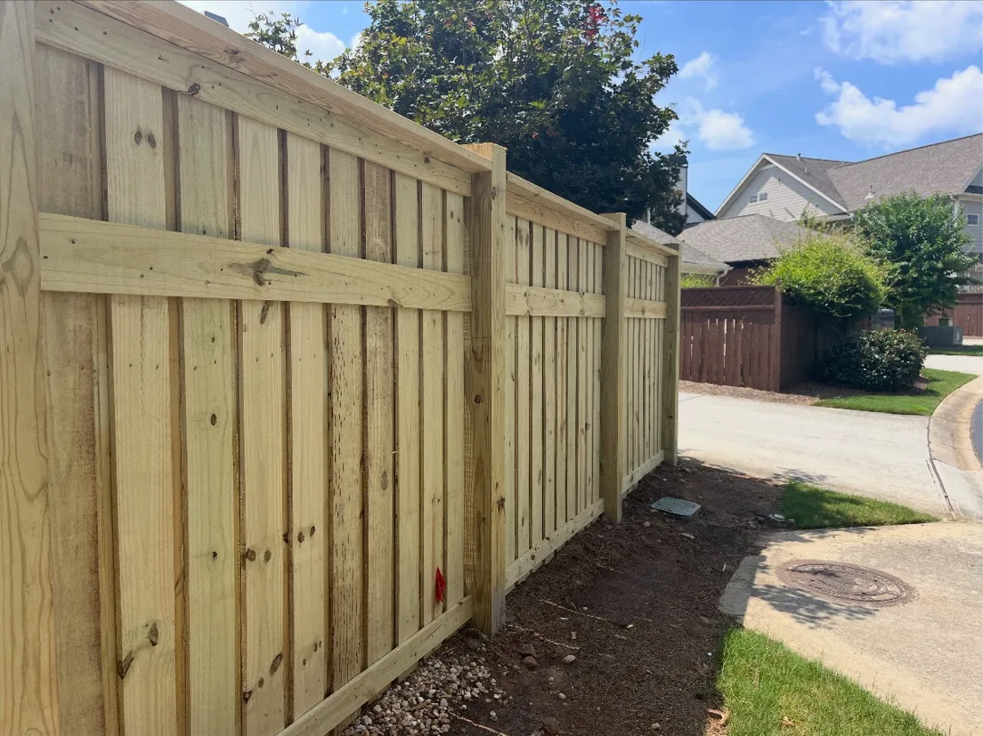 Six-foot capped board-on-board wood privacy fence with accent trim board in Suwanee, Georgia
